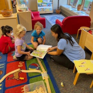 Preschool students with teacher reading.